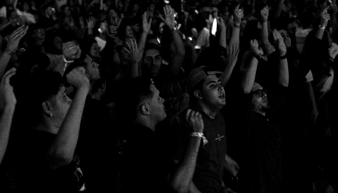 Público de mãos levantadas durante o louvor